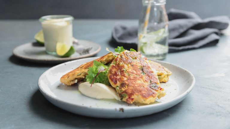 Image of the corn fritters plated with avocado