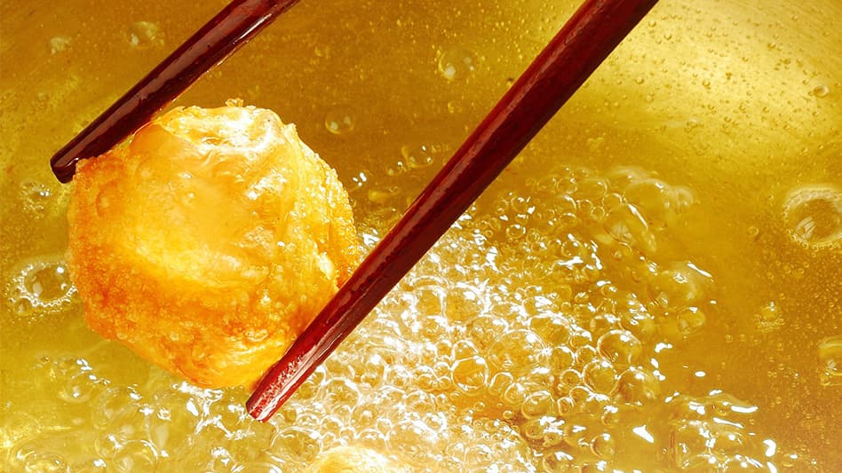 Donut being dried in vegetable oil