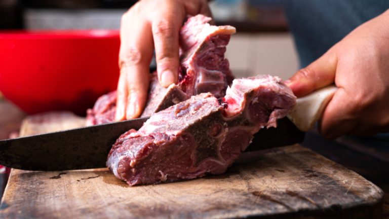 image of a chef cutting into a large piece of meat